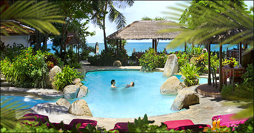A photo of the pool, with clear blue sea behind it.